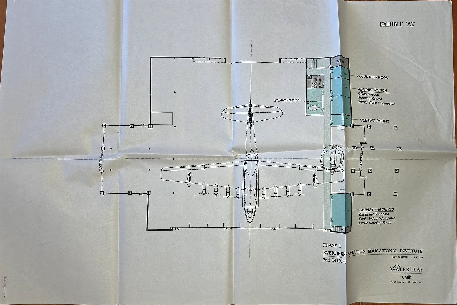 Folded plan sheet marked Exhibit A2: Phase 1, Evergreen Aviation Educational Institute, 2nd Floor, by Waterleaf, with the Spruce Goose in the center and a wing of offices and a library along one side