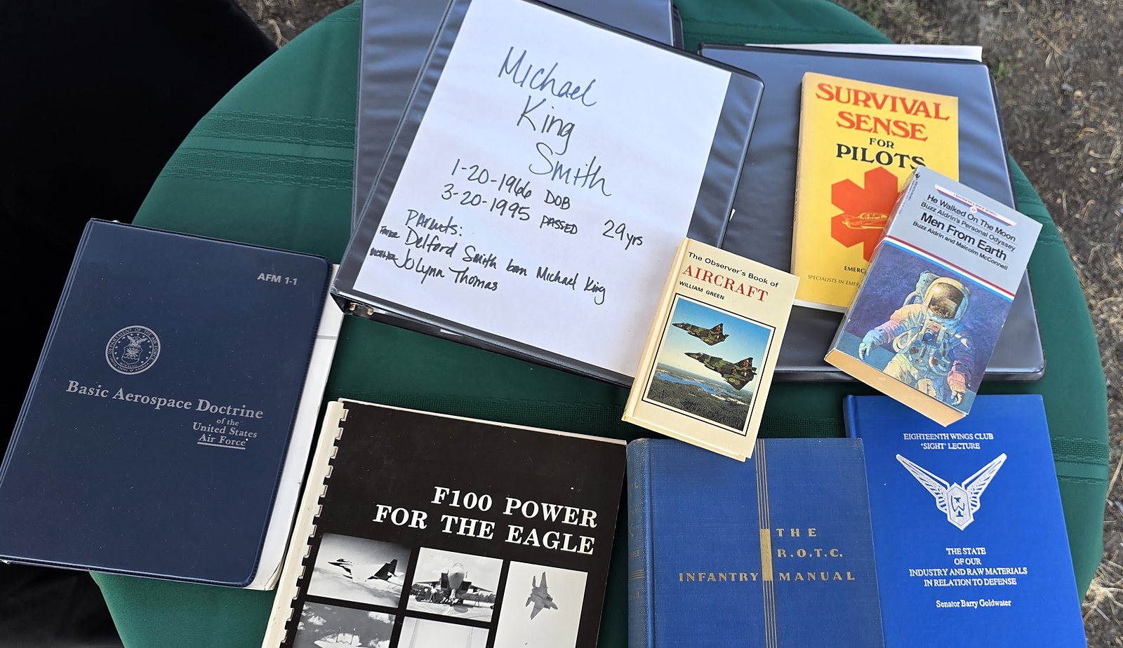 Binder labeled Michael King Smith with aviation books on a table